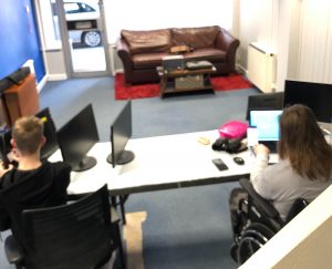 Two people sharing a desk as they work in an office