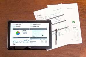 a printed analytics report and a tablet showing another analytics report