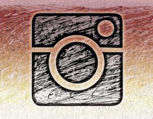 Pastel on Canvas sketch of the Instagram logo in black, with the trademark instagram colour gradient in the background.