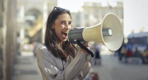 Woman shouting into a loudspeaker - a metaphor for what successful social media marketing does online.