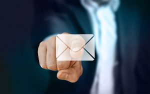 a man in a suit reaching out towards your screen, as if tapping a large envelope icon.