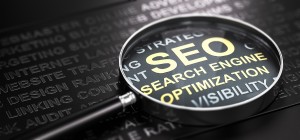 Magnifying glass and many words over a black background, with the text SEO (Search Engine Optimization) written in golden letters.