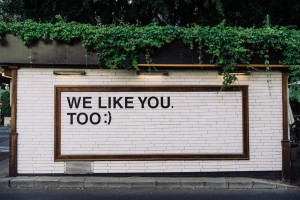 Billboard in urban setting reading 'we like you too'.